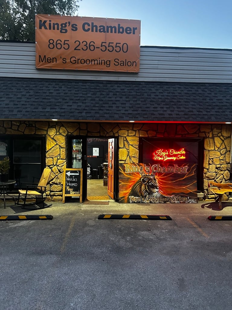 Kings Chamber Mens Grooming Salon storefront with orange sign, stone facade, and neon window display