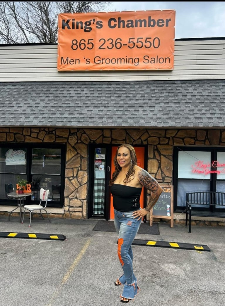 Woman standing in front of Kings Chamber Mens Grooming Salon storefront wearing black top and jeans